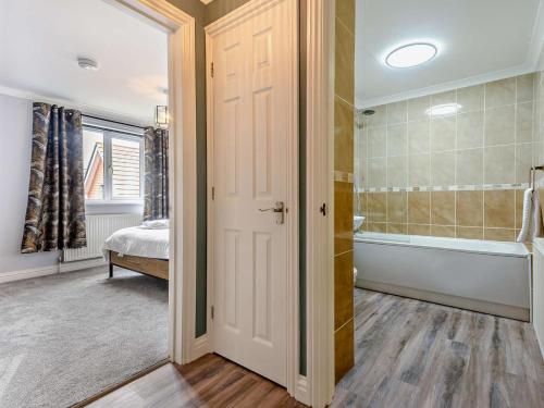 a bathroom with a tub and a shower and a door at 2 Bed in Freshwater oc-94561 in Freshwater