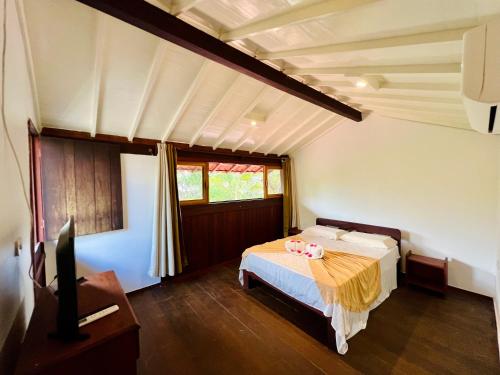 a bedroom with a bed with two pink dolls on it at Pousada e Restaurante do Paulo in Jijoca de Jericoacoara