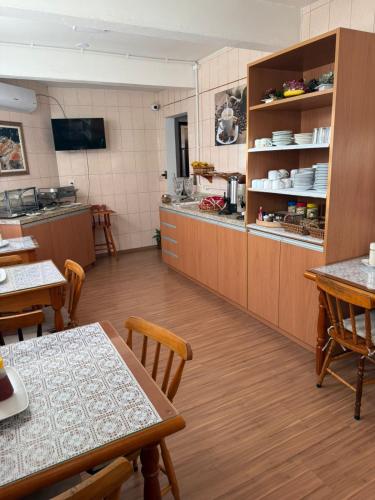 a kitchen with wooden cabinets and a table and chairs at Hotel Ibajé in Bagé