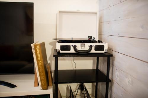 a toaster oven sitting on a stand next to a tv at Praia - Boutique Garden Ocean View Suite in the Countryside - Vila Pilar in Ponta Delgada