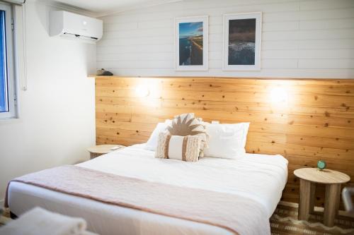 a bedroom with a large white bed with wooden walls at Praia - Boutique Garden Ocean View Suite in the Countryside - Vila Pilar in Ponta Delgada