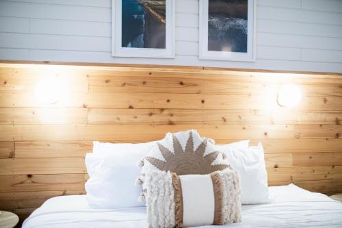 a bed with white pillows and a wooden headboard at Praia - Boutique Garden Ocean View Suite in the Countryside - Vila Pilar in Ponta Delgada