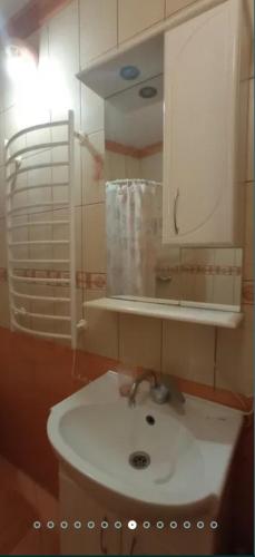 a bathroom with a white sink and a mirror at Затишні Апартаменти Берегове in Berehove
