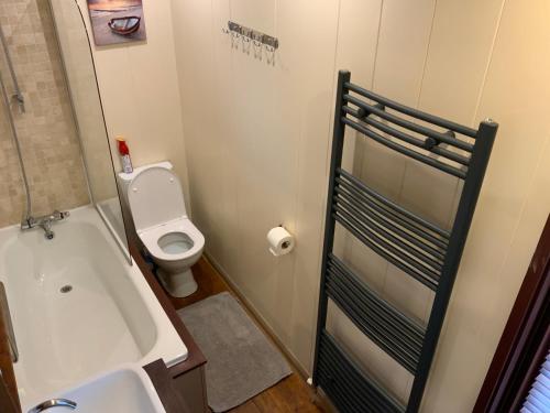 a bathroom with a bath tub and a toilet at Skye Lodge in Tighnabruaich