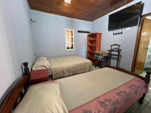 a bedroom with two beds and a flat screen tv at Punto Clave in Posadas