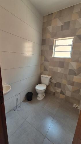 a bathroom with a toilet and a sink at Chácara Anna Julia in Piedade