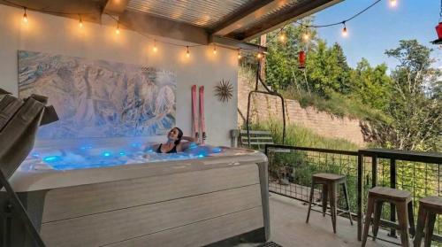 a woman laying in a hot tub on a patio at Side-by-Side Homes Multi-level with Views Ski Trail in Park City