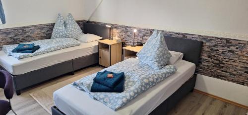 two beds in a room with blue pillows on them at Haus Hoogendam in Leoben