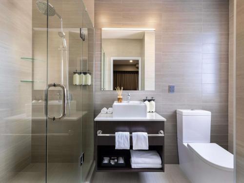 a bathroom with a sink and a shower and a toilet at The Sebel Auckland Manukau in Auckland