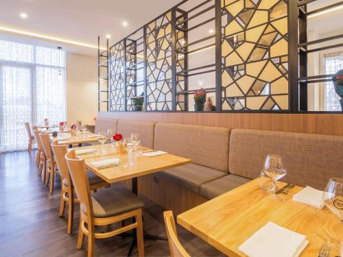 a dining room with wooden tables and chairs at The Sebel Auckland Manukau in Auckland