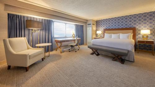 a hotel room with a bed and a desk and a chair at Tropicana Atlantic City, A Caesars Destination in Atlantic City