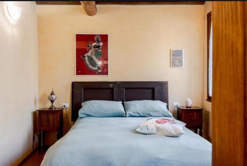 a bedroom with a bed with a blue comforter at La Locanda di Diogene in Case Reggiani