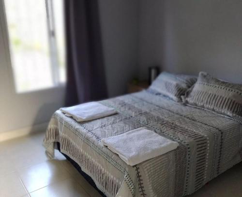 a white bed in a room with a window at Complejo Los Olivos in Ciudad Lujan de Cuyo