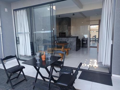 a dining room with a table and chairs and a kitchen at Casa Gourmet Próx Marco Argentina Paraguai e Centro in Foz do Iguaçu