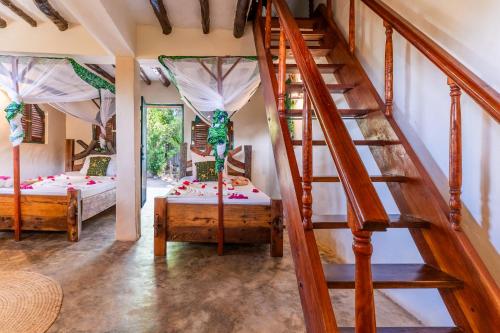 a room with two beds and a staircase at Demani Lodge Zanzibar in Paje