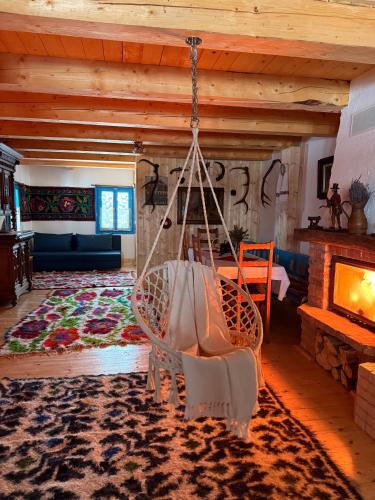a swing in a living room with a fireplace at La Patru Daci in Ocna Şugatag