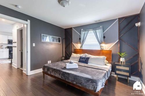a bedroom with a large bed with a blue wall at City-Center 2BR Near Attractions in Indianapolis