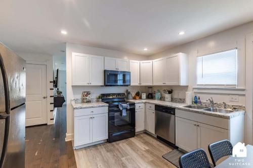 a kitchen with white cabinets and black appliances at City-Center 2BR Near Attractions in Indianapolis