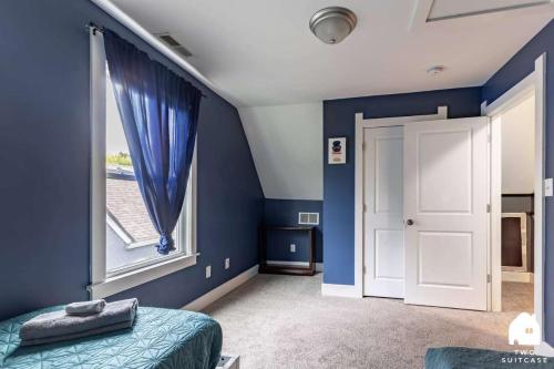 a bedroom with blue walls and a large window at City-Center 2BR Near Attractions in Indianapolis