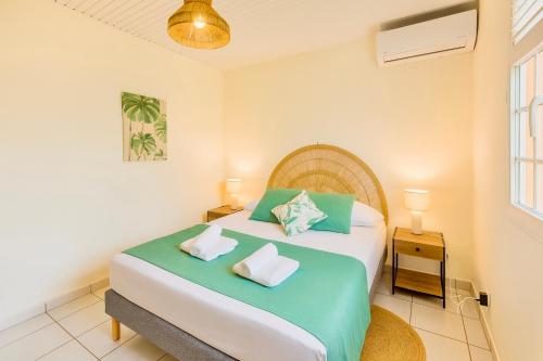 a bedroom with a large bed with two pillows at La villa Yuna in Le Vauclin
