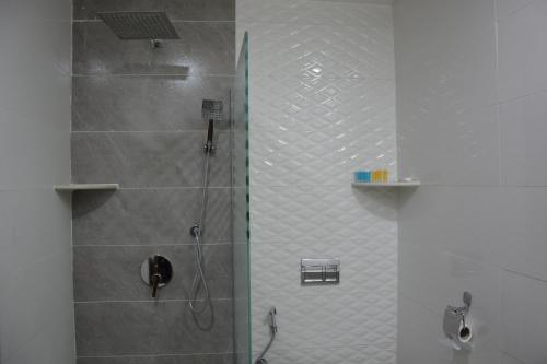 a bathroom with a shower with a glass door at MyFlower 3 Hotel in Erbil