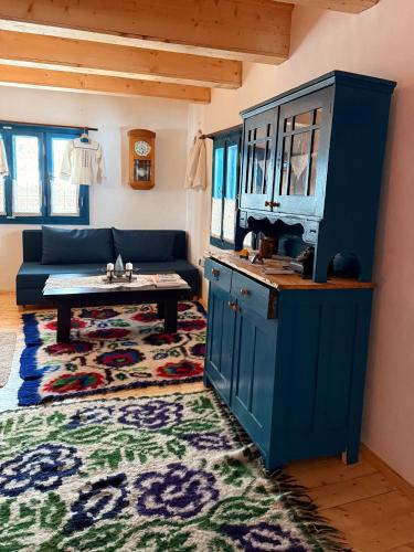 a living room with a blue couch and a table at La Patru Daci in Ocna Şugatag