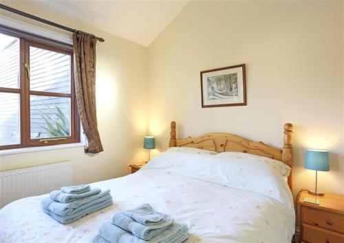 a bedroom with a bed with towels on it at 1 Bed in Beccles oc-hfc in Wangford