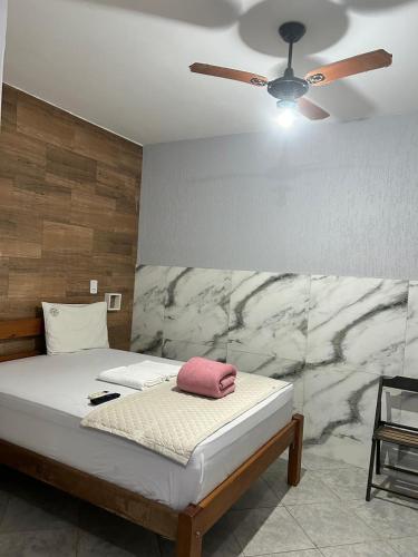 a bedroom with a bed with a ceiling fan at Pousada Cantinho da Jú in Pirenópolis