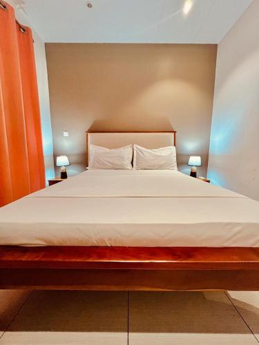 un grande letto in una stanza con due lampade di Saphir Home 