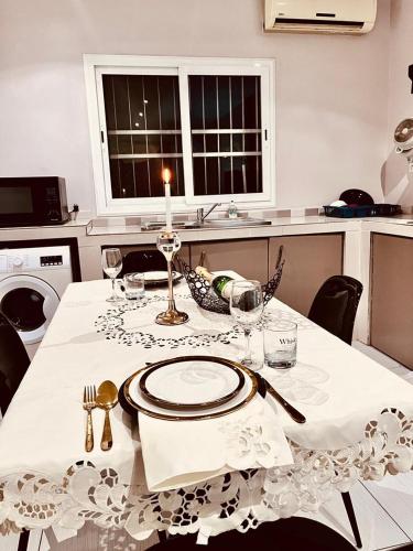 un tavolo bianco con una candela sopra di Saphir Home 