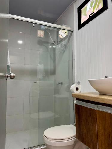 a bathroom with a shower and a toilet and a sink at Minca Seasons Birds in Minca