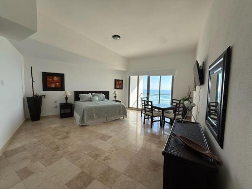 a bedroom with a bed and a table and chairs at Departamento Playa Punta Diamante in Acapulco
