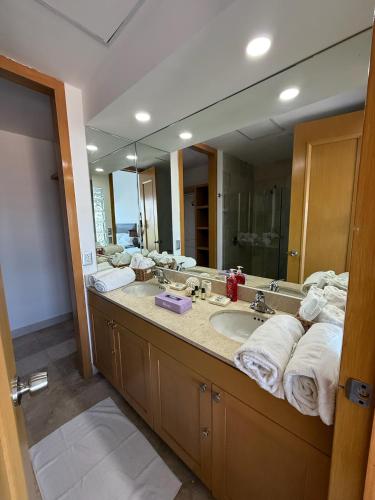 a bathroom with a sink and a large mirror at Departamento Playa Punta Diamante in Acapulco
