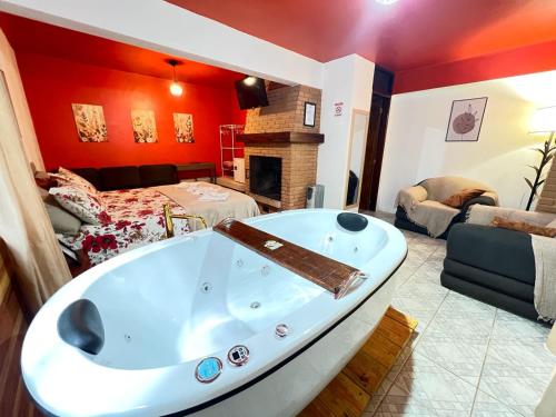 a bathroom with a tub in a room with a bed at Villaggio Farnese in Campos do Jordão
