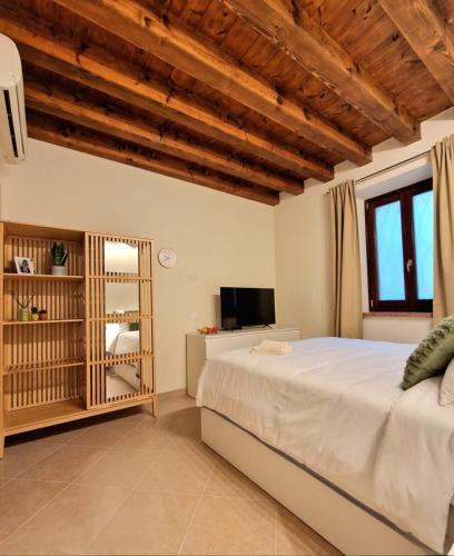 a bedroom with a large bed and a television at HolidHome - Soave Borgo Suite - Mini appartamento di charme nelle mura medievali in Soave