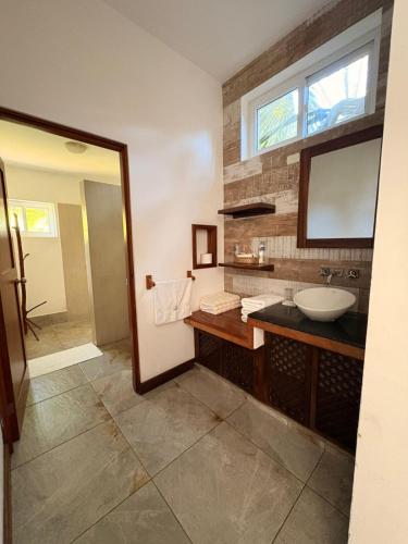 a bathroom with a sink and a mirror at Dos Mundos Pacific Resort in Monterrico