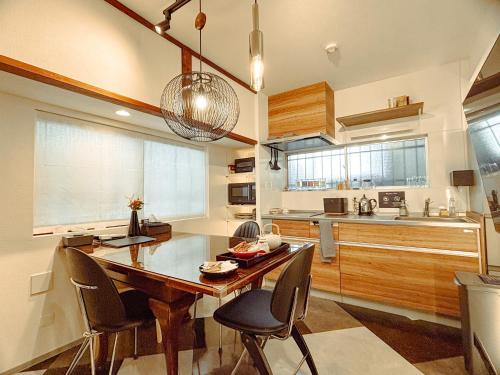 a kitchen with a wooden table and chairs in it at Chronos House Tokyo Kitasenju - Time Travel Stay in Tokyo