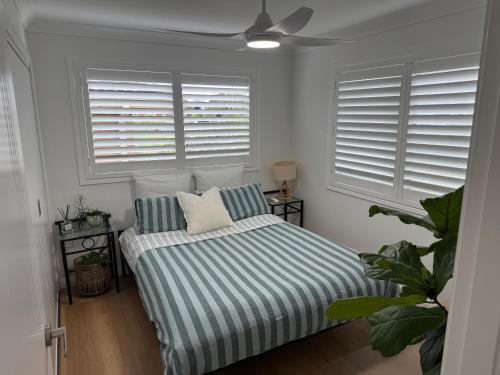 a bedroom with a bed and two windows at SAND Haus in North Haven