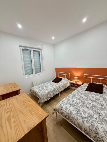 a room with two beds and a table at La Maison du Souvenir in Beaucourt-sur-lʼAncre