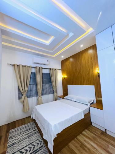 a bedroom with a white bed and a blue ceiling at Best place appartement in Cotonou