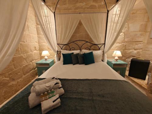 a bedroom with a large bed with two night stands at Ta' Ġilarda Boutique Living in Birbuba