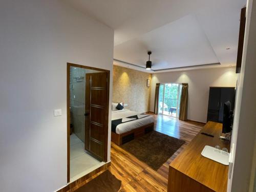 a living room with a bed and a mirror at Nellarachal Homestay in Ambalavayal