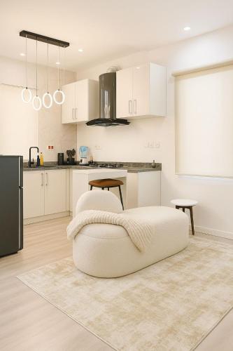 a kitchen with white cabinets and a bed in a room at Gift cozy 1 bedroom in Lekki