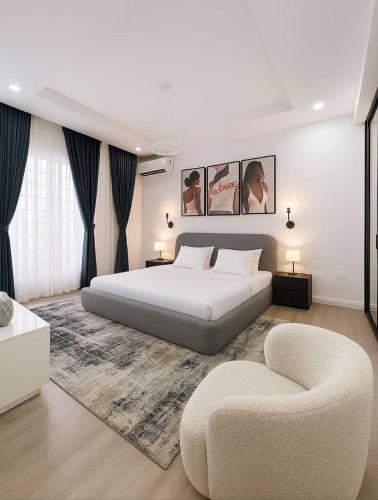 a bedroom with a large bed and a chair at Gift cozy 1 bedroom in Lekki