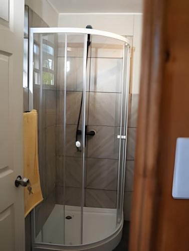 a shower with a glass door in a bathroom at Casa completa en Carretera Austral KM 23 con Fibra Óptica in Puerto Montt