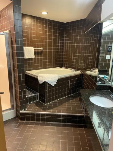 a bathroom with a bath tub and a sink at Apm Inn & Suites in Hagerstown
