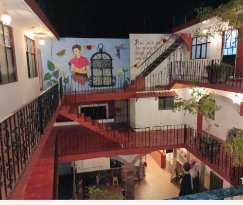 a staircase in a building with a mural on the wall at Hotel Kasa Sarita Centro Historico SMA in San Miguel de Allende