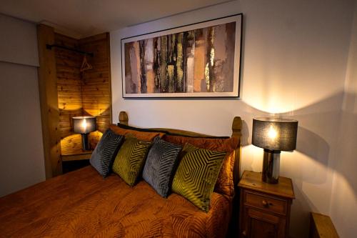 a bedroom with a bed with two lamps and a painting at Eeyore's Place in Hythe