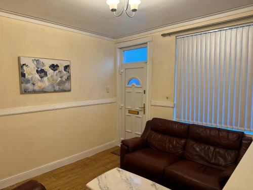 a living room with a couch and a window at Modern two Bedroom Home in Hartshill Great Location Easy Transport in Stoke on Trent