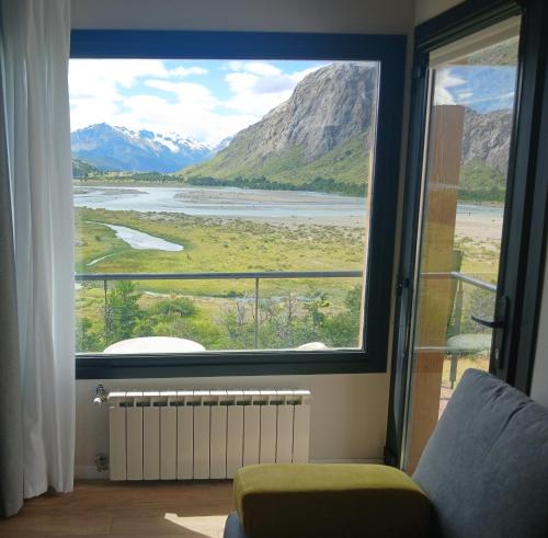 a room with a large window with a view of the mountains at Panorama Aparts Chalten in El Chalten